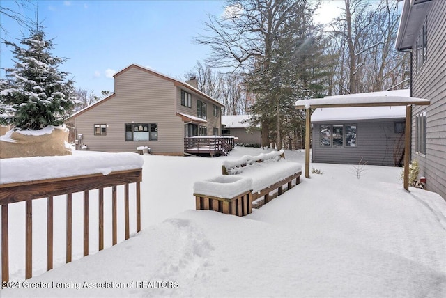 snowy yard featuring a wooden deck