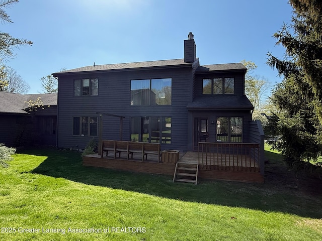 back of house featuring a chimney, a yard, and a wooden deck
