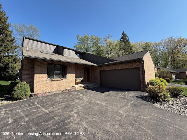 view of front of house featuring brick siding, asphalt driveway, a garage, and a shingled roof