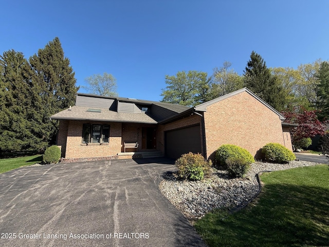 mid-century modern home with brick siding, driveway, and an attached garage