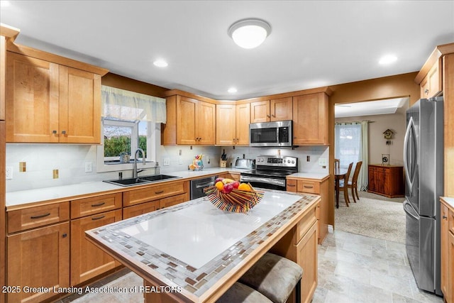 kitchen with stainless steel appliances, backsplash, a kitchen island, sink, and a kitchen bar