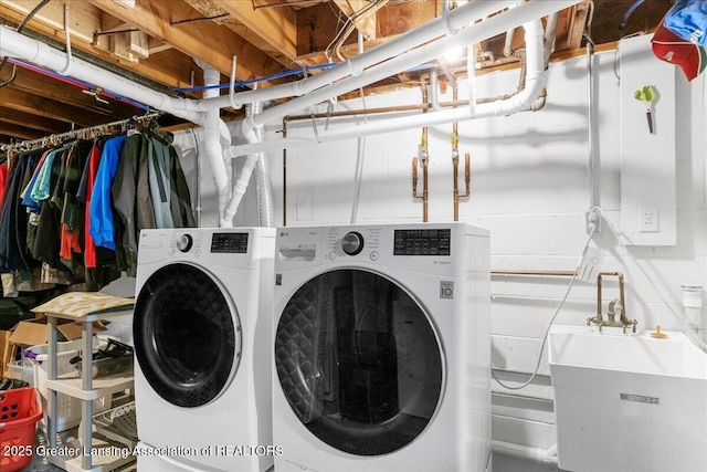 laundry area with independent washer and dryer and sink