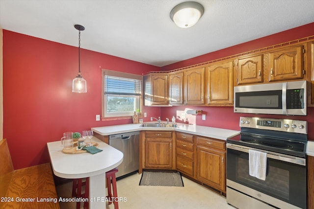 kitchen featuring hanging light fixtures, stainless steel appliances, and sink