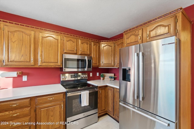 kitchen featuring a textured ceiling and stainless steel appliances