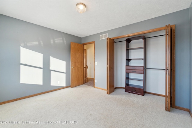 unfurnished bedroom featuring a closet and light colored carpet