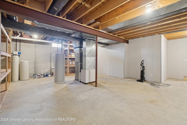 basement featuring heating unit and water heater