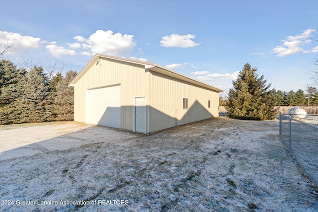 view of side of home featuring a garage and an outbuilding