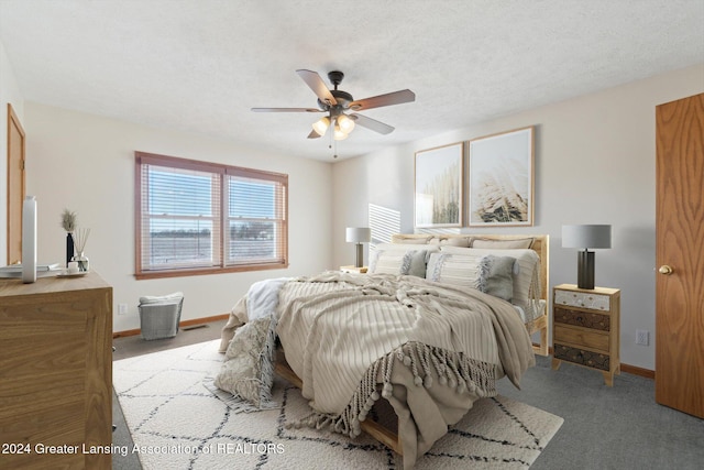 bedroom featuring light carpet, a textured ceiling, and ceiling fan