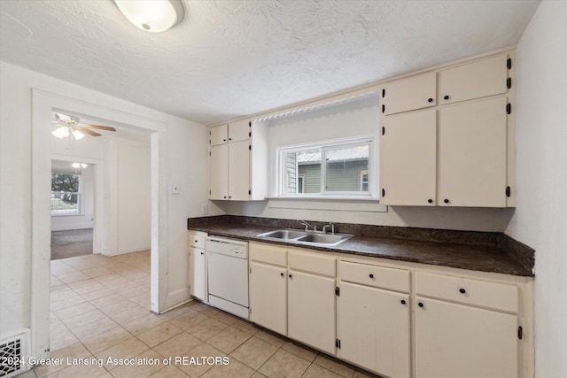 kitchen with white dishwasher, sink, ceiling fan, light tile patterned floors, and a textured ceiling