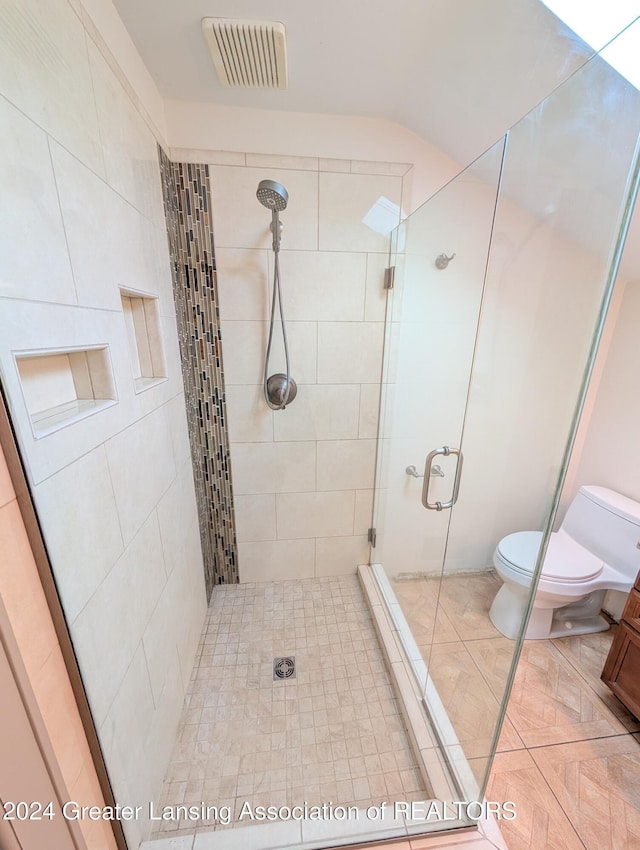 bathroom with toilet and an enclosed shower