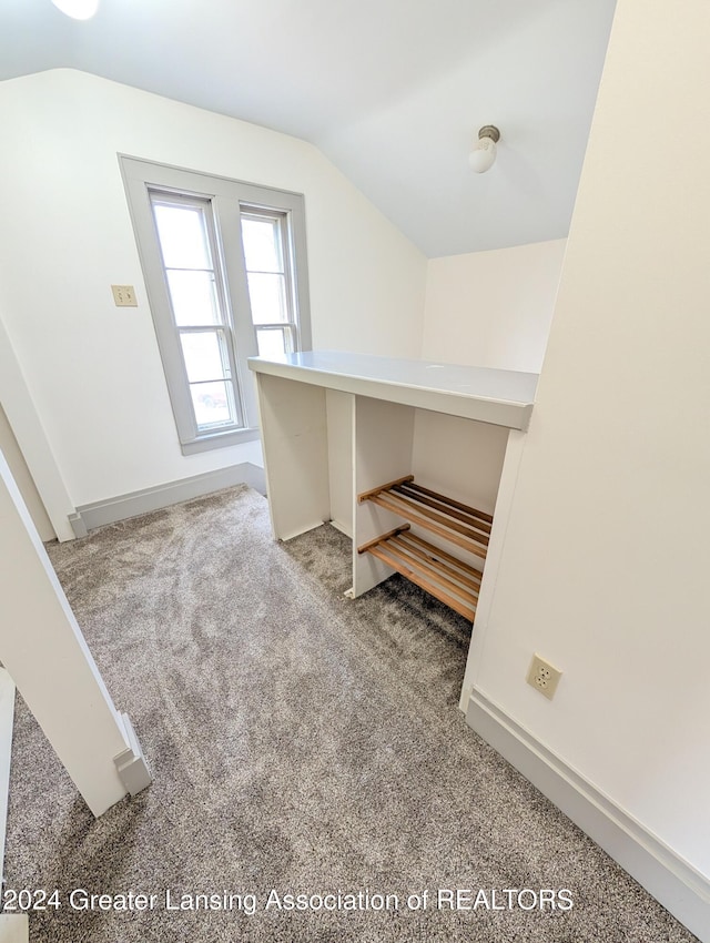 interior space with carpet flooring and vaulted ceiling