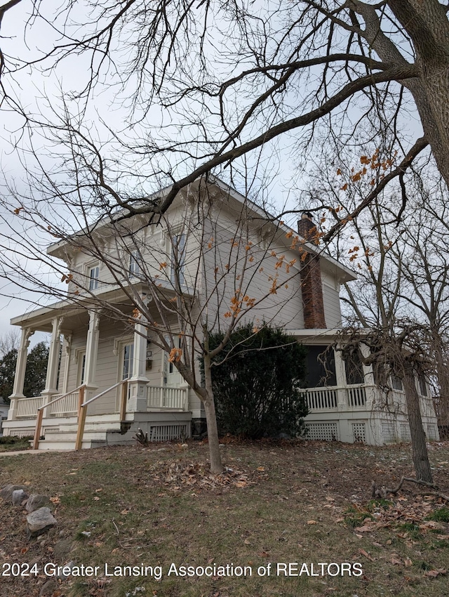 view of side of property featuring covered porch