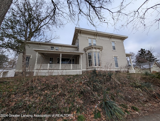 rear view of property featuring covered porch