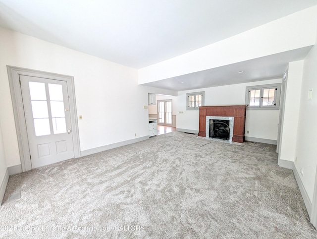 unfurnished living room featuring light carpet