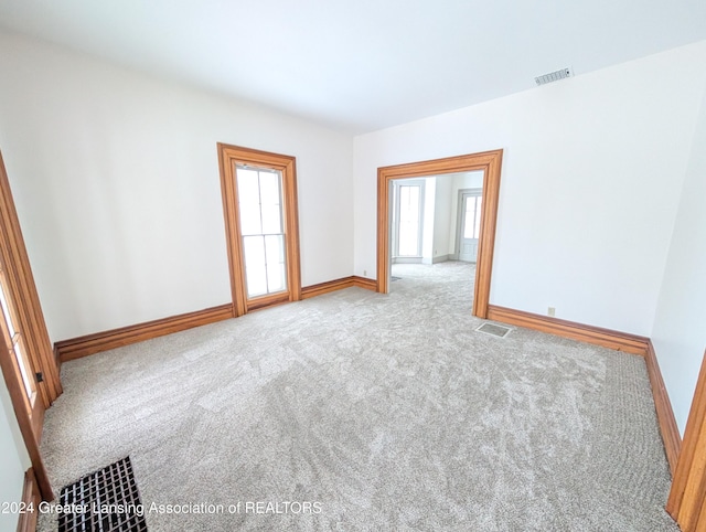 unfurnished room with a wealth of natural light and light colored carpet