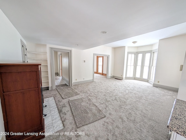 unfurnished living room featuring light carpet