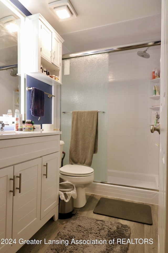 bathroom with walk in shower, toilet, vanity, and hardwood / wood-style flooring