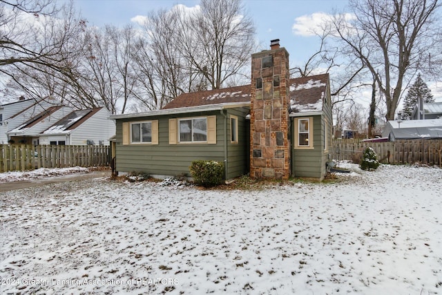 view of snow covered back of property