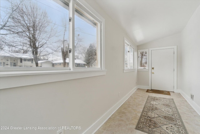 entrance foyer with lofted ceiling and light tile patterned floors