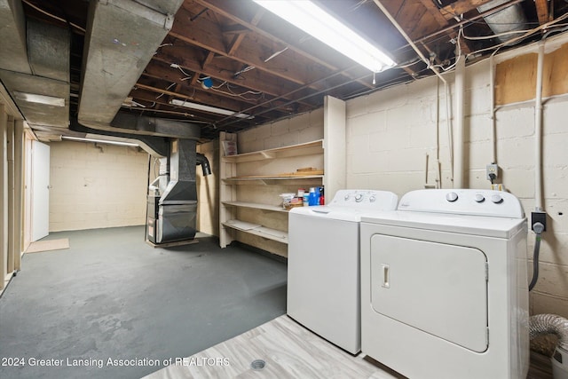 clothes washing area featuring independent washer and dryer and heating unit