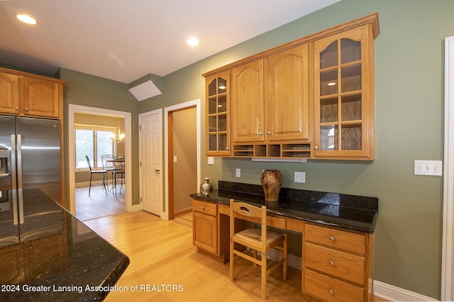 office space with built in desk and light hardwood / wood-style flooring