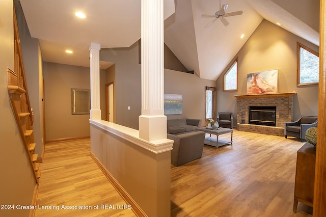 living room featuring ceiling fan, light hardwood / wood-style flooring, high vaulted ceiling, and ornate columns