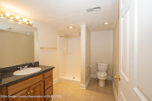 bathroom with toilet, a shower, and vanity