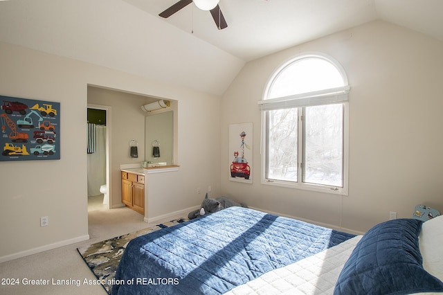 carpeted bedroom featuring lofted ceiling, ensuite bath, and ceiling fan