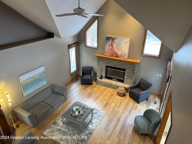 living room with lofted ceiling, a fireplace, ceiling fan, and wood-type flooring