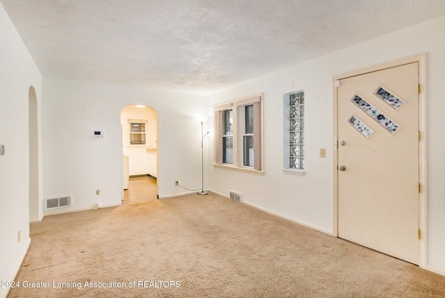 carpeted empty room featuring a textured ceiling