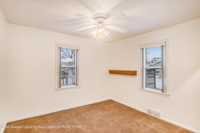 spare room with ceiling fan and light carpet