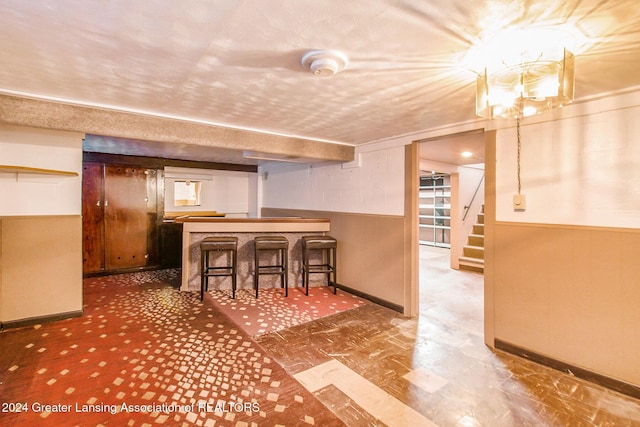 bar with wooden walls and a textured ceiling