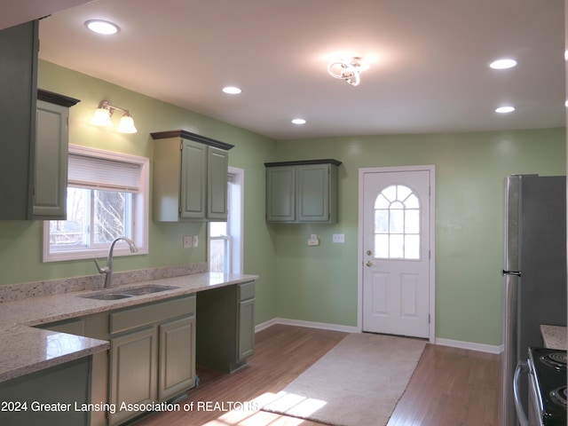 kitchen with stainless steel appliances, light hardwood / wood-style flooring, plenty of natural light, and sink