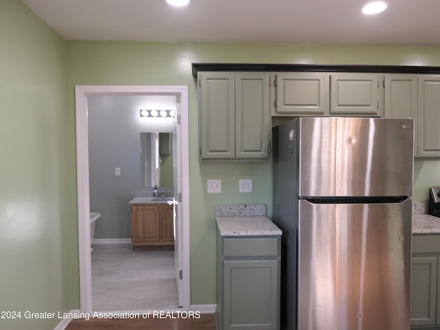 kitchen with gray cabinets, stainless steel fridge, and sink