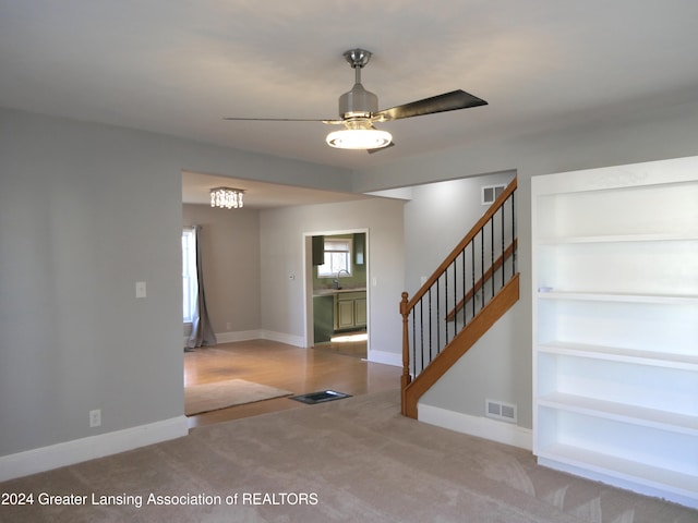 carpeted foyer featuring ceiling fan and sink