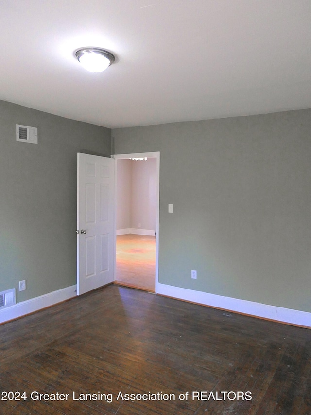 spare room with dark hardwood / wood-style flooring