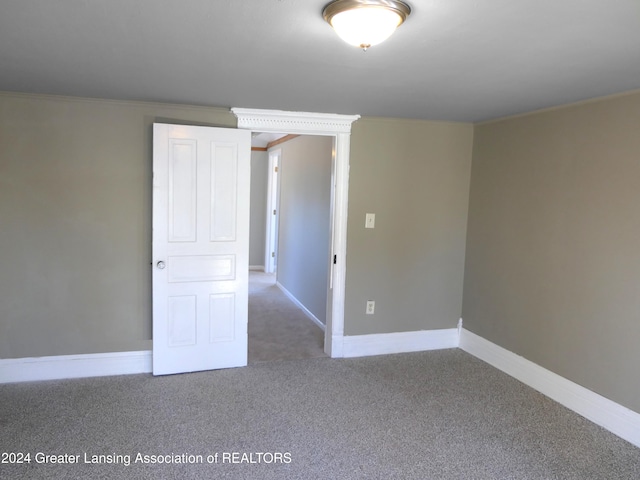 carpeted empty room featuring ornamental molding