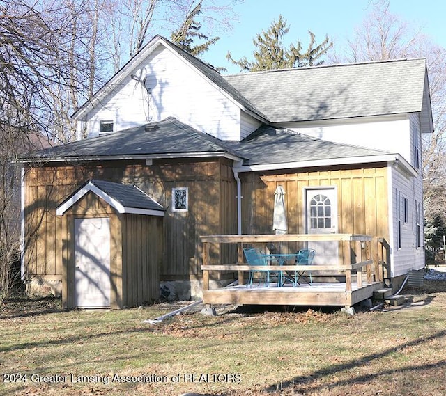 back of property with a yard and a deck