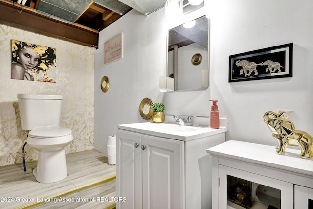 bathroom featuring vanity, wood-type flooring, and toilet