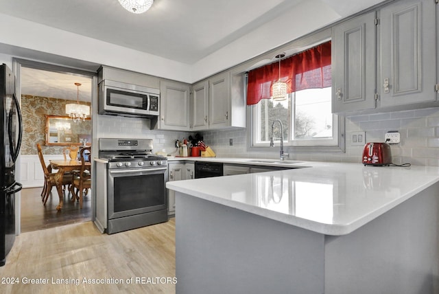 kitchen with gray cabinetry, sink, kitchen peninsula, and black appliances