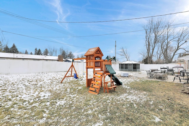 snow covered playground with a patio area