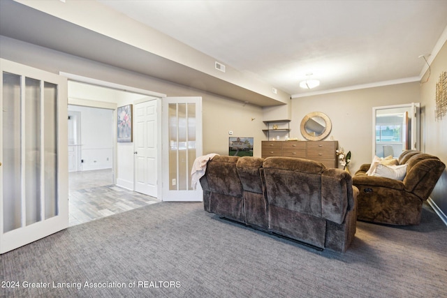 carpeted living room featuring french doors and ornamental molding