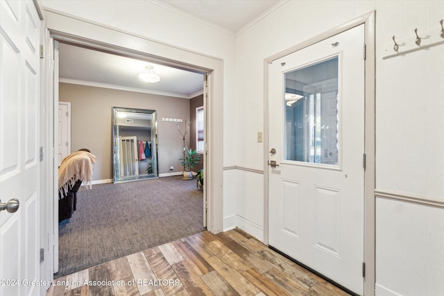 entryway with hardwood / wood-style floors and crown molding