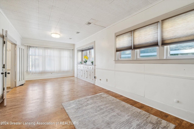 spare room featuring hardwood / wood-style floors and ornamental molding