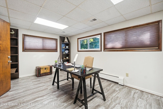 office area with a paneled ceiling, light hardwood / wood-style floors, and baseboard heating