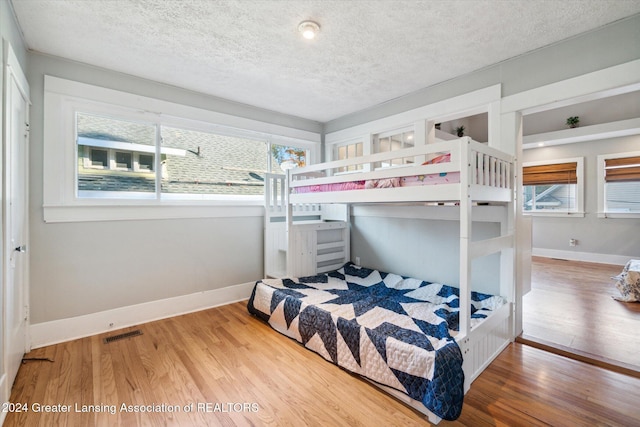 bedroom featuring hardwood / wood-style floors and a textured ceiling