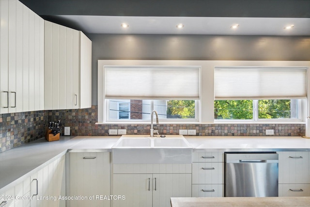 kitchen featuring decorative backsplash, a healthy amount of sunlight, sink, dishwasher, and white cabinets