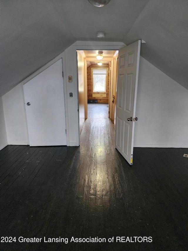 bonus room with dark hardwood / wood-style floors and vaulted ceiling