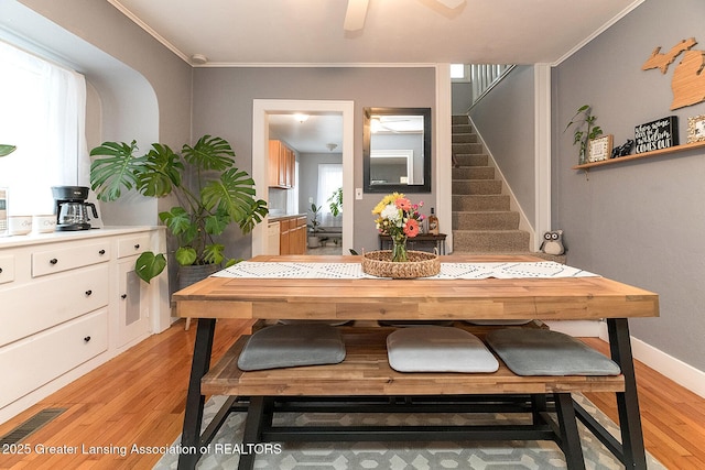 dining space featuring a healthy amount of sunlight, ceiling fan, ornamental molding, and light hardwood / wood-style floors