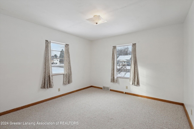 unfurnished room with carpet floors and plenty of natural light